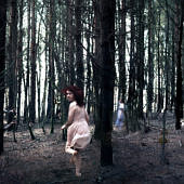 Menekülő nő egy erdő fái között