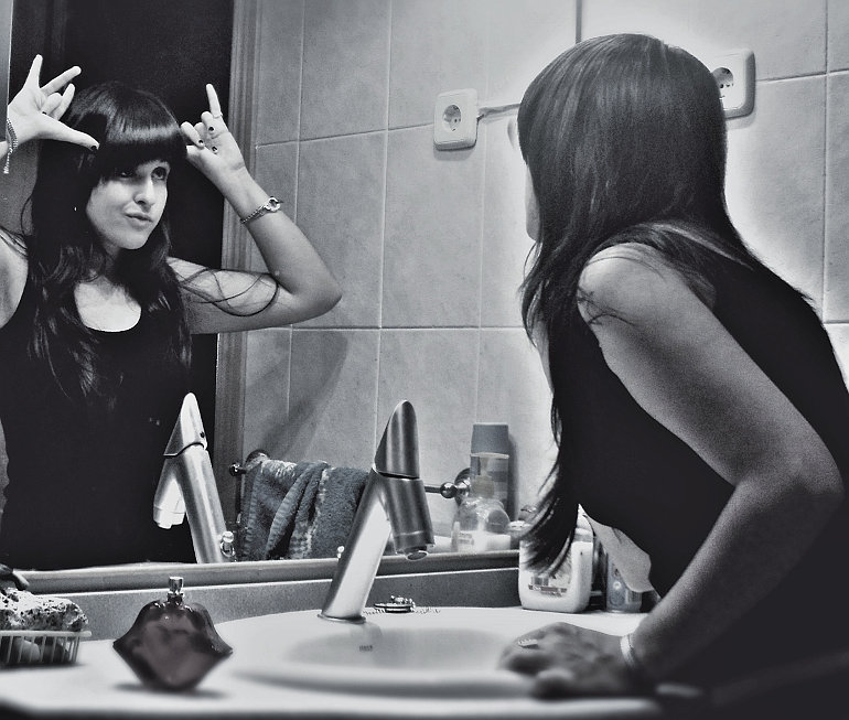 Egy nő, akivel csúfolódik a tükörképe